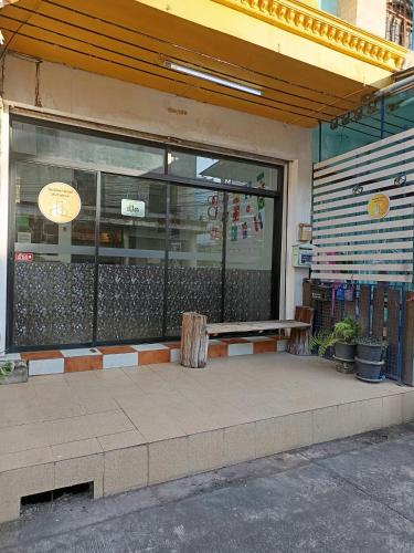 a bench in front of a building with a window at เส้นดี โฮสเทล Sendee Hostel in Phitsanulok