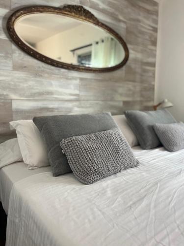 a bedroom with a bed with pillows and a mirror at Viento Azul Guest House in Punta del Este