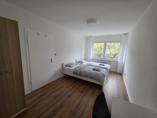 a small bedroom with a bed and a window at 3-Zimmer Wohnung - 3 OG in Duisburg