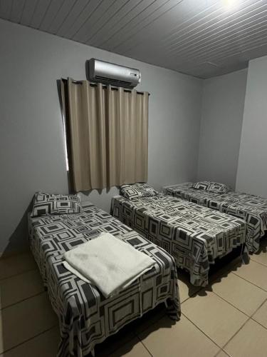 a room with two beds in a room at Pousada Gaivota in Trindade