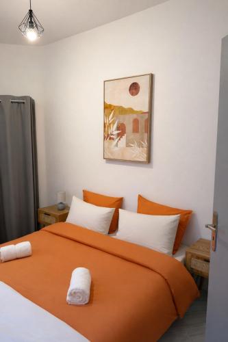 an orange bed with white pillows in a room at Le Cocon de la Cathédrale au cœur de Metz in Metz