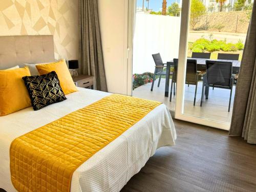 a bedroom with a bed and a balcony with a table at Alcazaba Lagoon & Private Beach Costa del Sol 1903 in Estepona