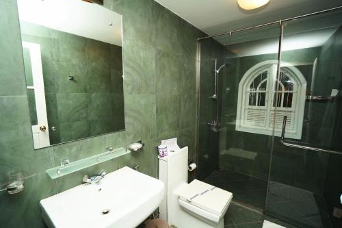 un bagno con lavandino, WC e specchio di Samindra Villa a Kandy