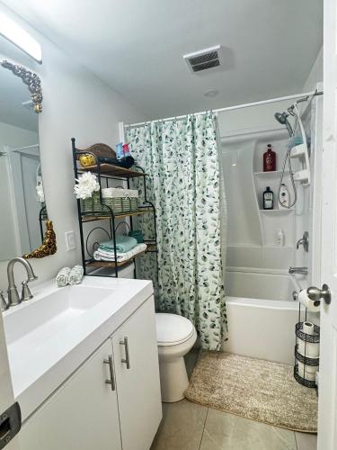 a bathroom with a toilet and a shower curtain at Peaceful in Moncton