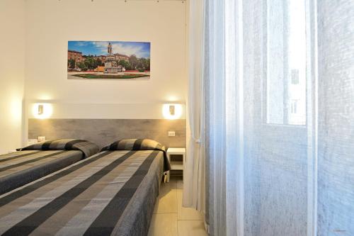 a hotel room with two beds and a window at La Piazza in Ancona