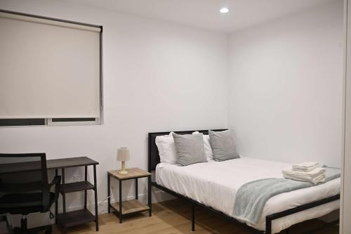 a bedroom with a bed and a table and a chair at Calm Luxe Ensuite Room near USC-Shared Home in Los Angeles
