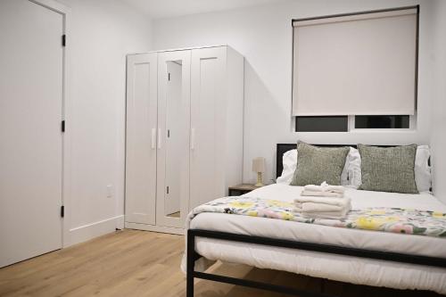 a bedroom with a large bed with white walls at Calm Luxe Ensuite Room near USC-Shared Home in Los Angeles