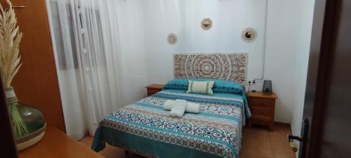 a bedroom with a bed with two pillows on it at La Virgen del Mar in Las Hortichuelas Bajas