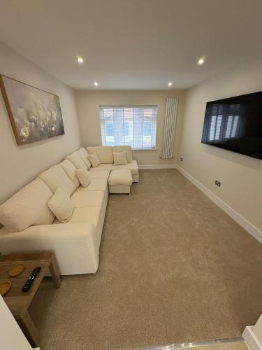 a living room with a white couch and a flat screen tv at Santíago Retreat in Wenvoe