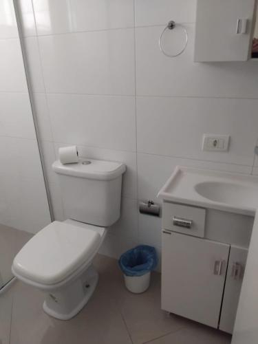 a white bathroom with a toilet and a sink at 502 edificio premieri in Piratuba