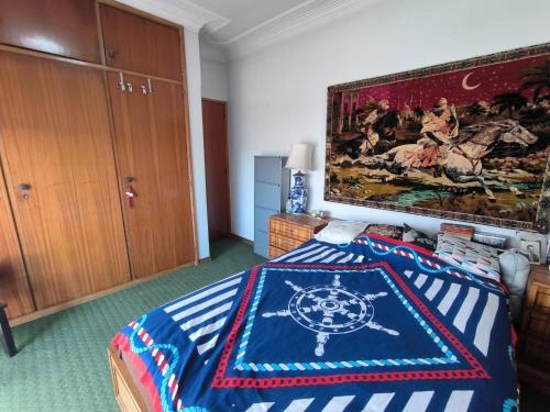 a bedroom with a bed with a painting on the wall at GamaBarros1-Charneca in Charneca