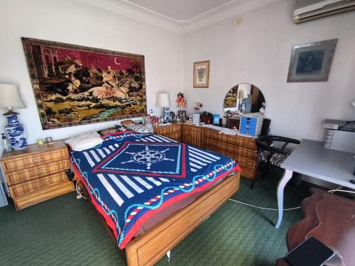 a bedroom with a bed and a painting on the wall at GamaBarros1-Charneca in Charneca
