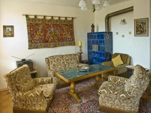 a living room with chairs and a table and a rug at Apartment mit Pool und überdachtem Balkon by Interhome in Beerfelden