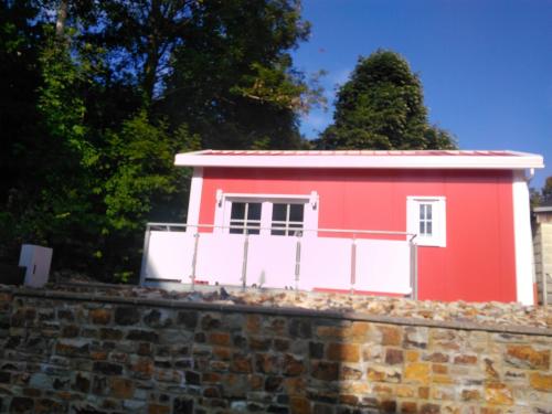 a red house on top of a brick wall at Holiday Home Tiny Haus Westerwald by Interhome in Bad Marienberg