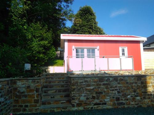 a small pink house on a brick wall at Holiday Home Tiny Haus Westerwald by Interhome in Bad Marienberg