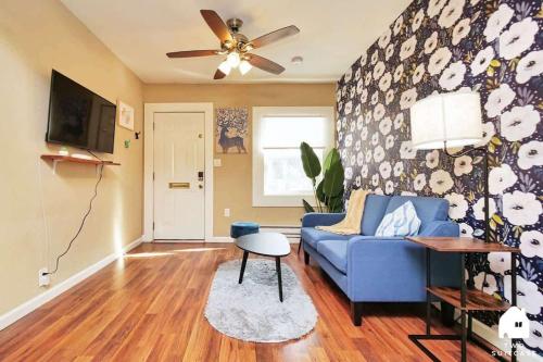 a living room with a blue couch and a ceiling fan at Central Berkeley Garden Oasis in Berkeley