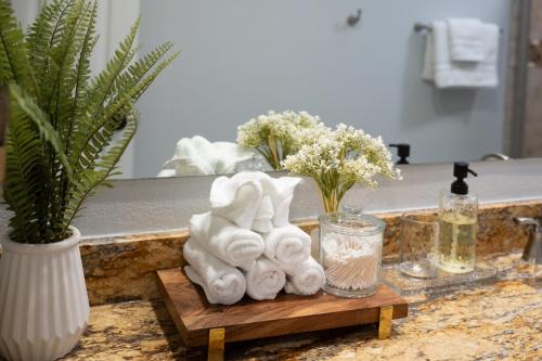 a bathroom sink with towels on a wooden tray at DFW Spacious Cozy Modern Villa in Grand Prairie
