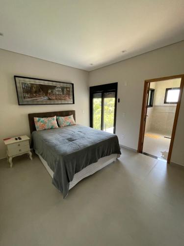 a bedroom with a large bed in a room at Casa represa Piracaia in Piracaia