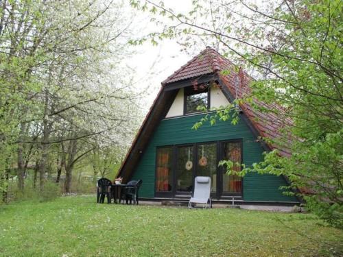 a green house with a table and chairs in front of it at Holiday Home Kirschblüte by Interhome in Ronshausen