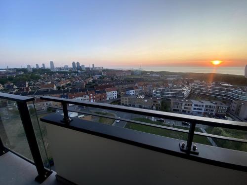 a view of a city at sunset from a balcony at Joy at sea in Bredene-aan-Zee
