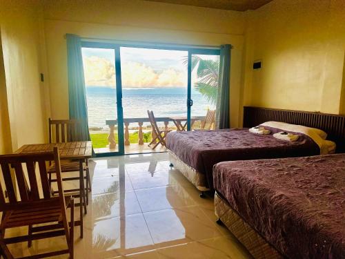 a bedroom with two beds and a view of the ocean at Rio Beach Resort in Alegria