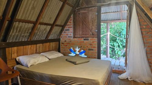 a bedroom with a bed in a room with a window at Florada in Ilha do Maiandeua