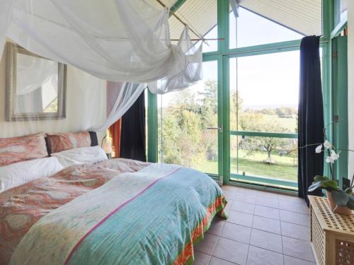 a bedroom with a bed and a large window at Apartment Immas Welt by Interhome in Utting am Ammersee