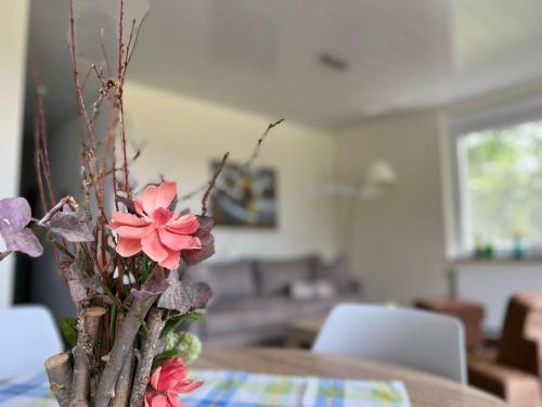 a vase with pink flowers sitting on a table at Apartment Kommerswag by Interhome in Pittenbach