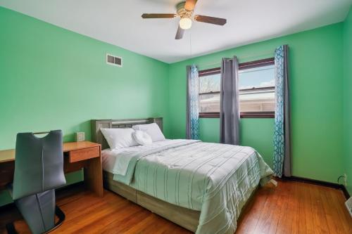 a bedroom with green walls and a bed with a desk at CBI Haven 1 & 2 in Milwaukee