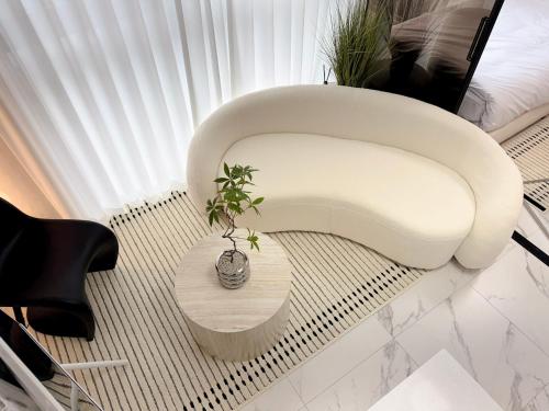 a white chair and a table in a room at 2BR City Hall Station 6min, Myeongdong & Namsan Stay in Seoul