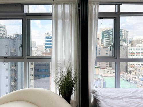 a bedroom with a window view of a city at 2BR City Hall Station 6min, Myeongdong & Namsan Stay in Seoul
