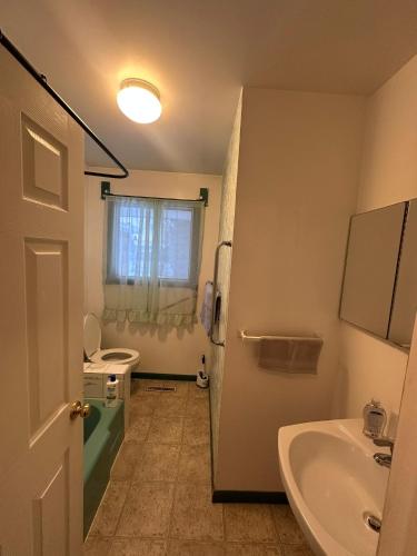 a bathroom with a sink and a tub and a toilet at 3 Private rooms with built-in closet & desk in Edmonton