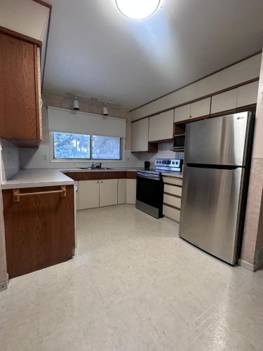 a large kitchen with a stainless steel refrigerator at 3 Private rooms with built-in closet & desk in Edmonton