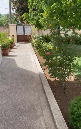 a walkway in a garden with flowers and plants at Appartement Les Rosiers in Ifrane