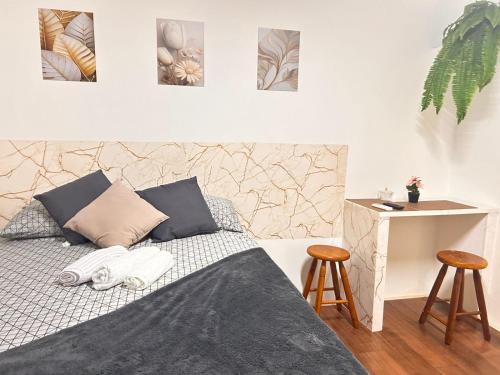 a bedroom with a bed and two stools at Condomínio Boa Ideia apart completo ao lado North Shopping Maracanaú in Maracanaú