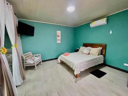 a bedroom with a bed and a green wall at Paraiso En-suite #3 in Parrita
