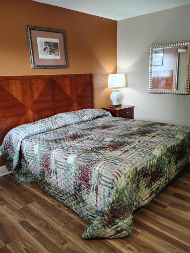 a bedroom with a bed and a lamp on a wooden floor at Gated 1 King BR1 Bath Apt with Full Kitchen 124 in Baton Rouge
