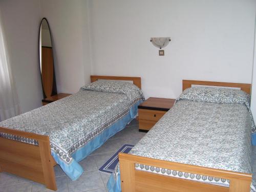 dwa łóżka w pokoju z deską surfingową na ścianie w obiekcie L'Ostu del Povr-Om w mieście Pinasca 