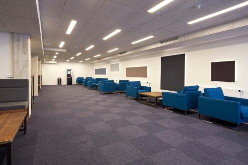 an empty room with blue chairs and a classroom at Living Suites in Nærum