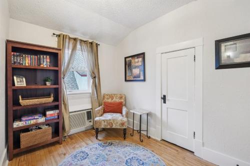 a living room with a chair and a book shelf at 1BR Apartment Across from Como Lake - Bayberry in Saint Paul