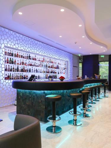 a bar with stools in a hotel lobby at Le Royal Hotels & Resorts Luxembourg in Luxembourg