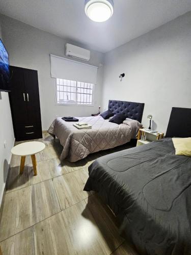 a bedroom with two beds and a table at Casa Valle Viejo con Cochera Cubierta Gratis in San Fernando del Valle de Catamarca
