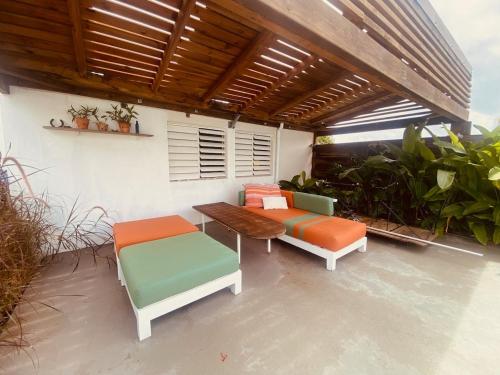 a patio with two chairs and a wooden table at Villa design et piscine Le Gosier in Le Gosier