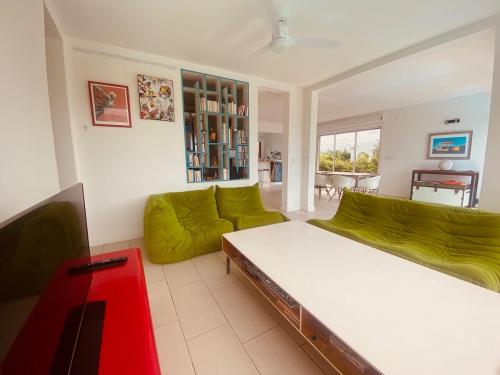 a living room with a bed and a green couch at Villa design et piscine Le Gosier in Le Gosier