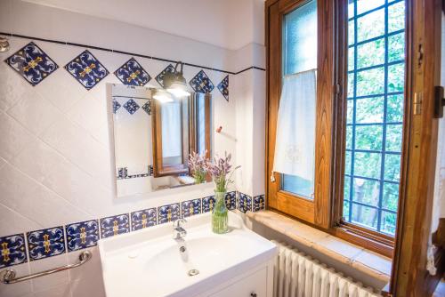 a bathroom with a sink and a mirror and a window at BorgoCuore in Todi