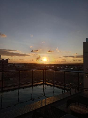 a view of the sunset from the balcony of a building at Flat com piscina na cobertura em Intermares in Cabedelo