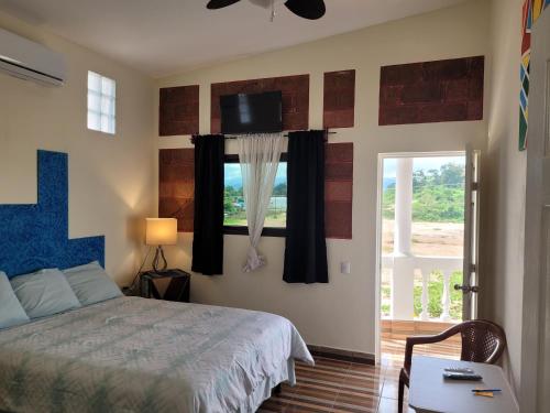 a bedroom with a bed and a window with a tv at Luxury Posada inn in Los Amates