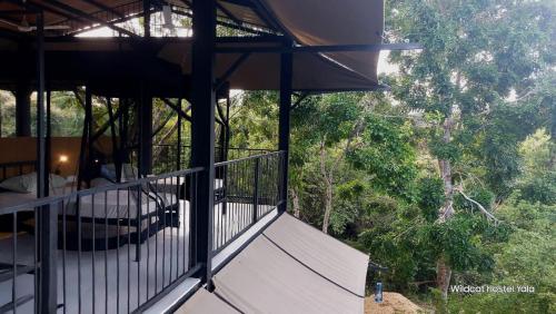 a balcony of a house with trees in the background at Wildcat hostel Yala in Kataragama