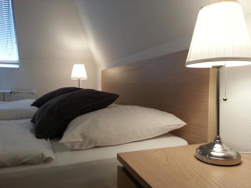 a bedroom with a bed with pillows and a lamp at Retro Hotel Villa Ostrava in Ostrava