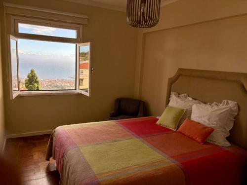 a bedroom with a bed with a large window at Santos Living Rentals in Funchal